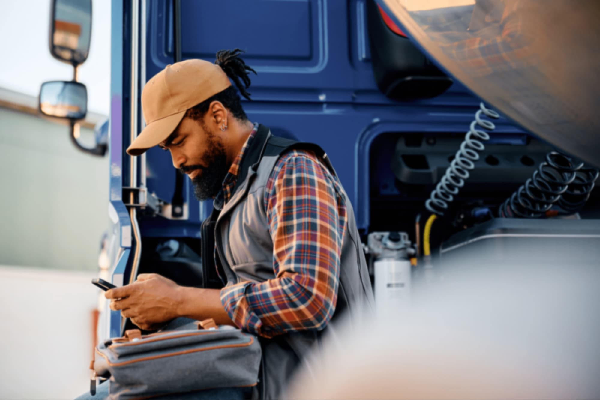 Man outside of a truck on a mobile device
